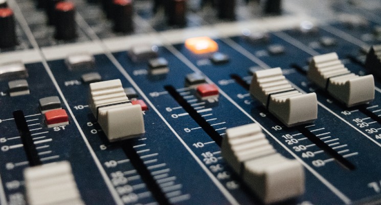 up close image of sound mixing board in music studio intro music