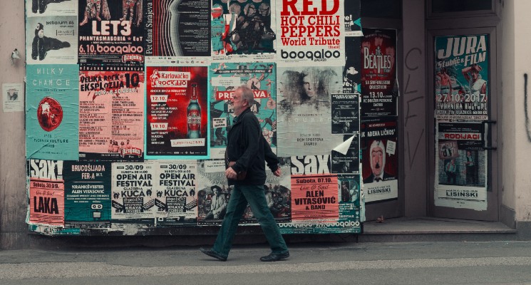 man walking past wall covered in adverts best advertisements blog banner
