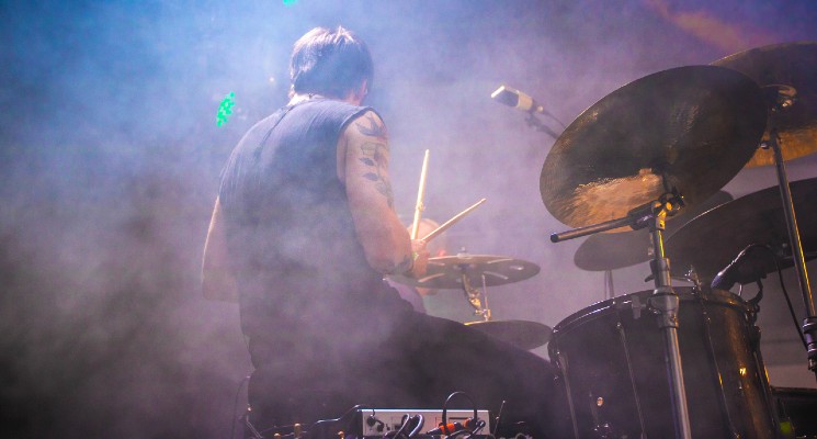 someone playing the drums on a smoky stage history of rock music blog header image pexels