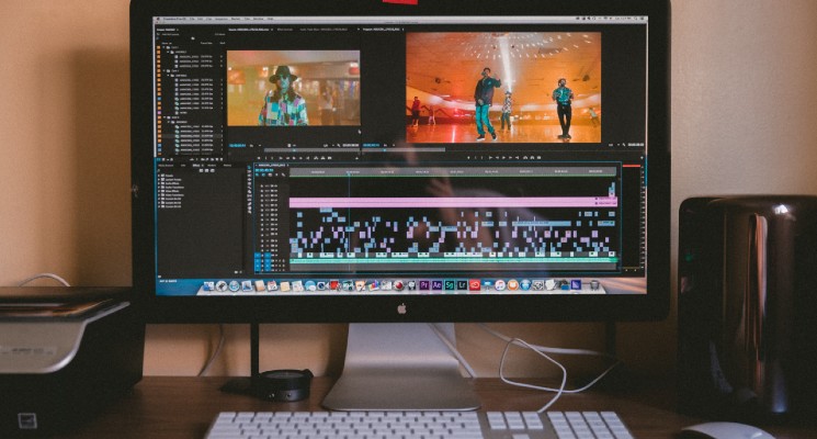 person editing video and audio on a mac unsplash image youtube music blog